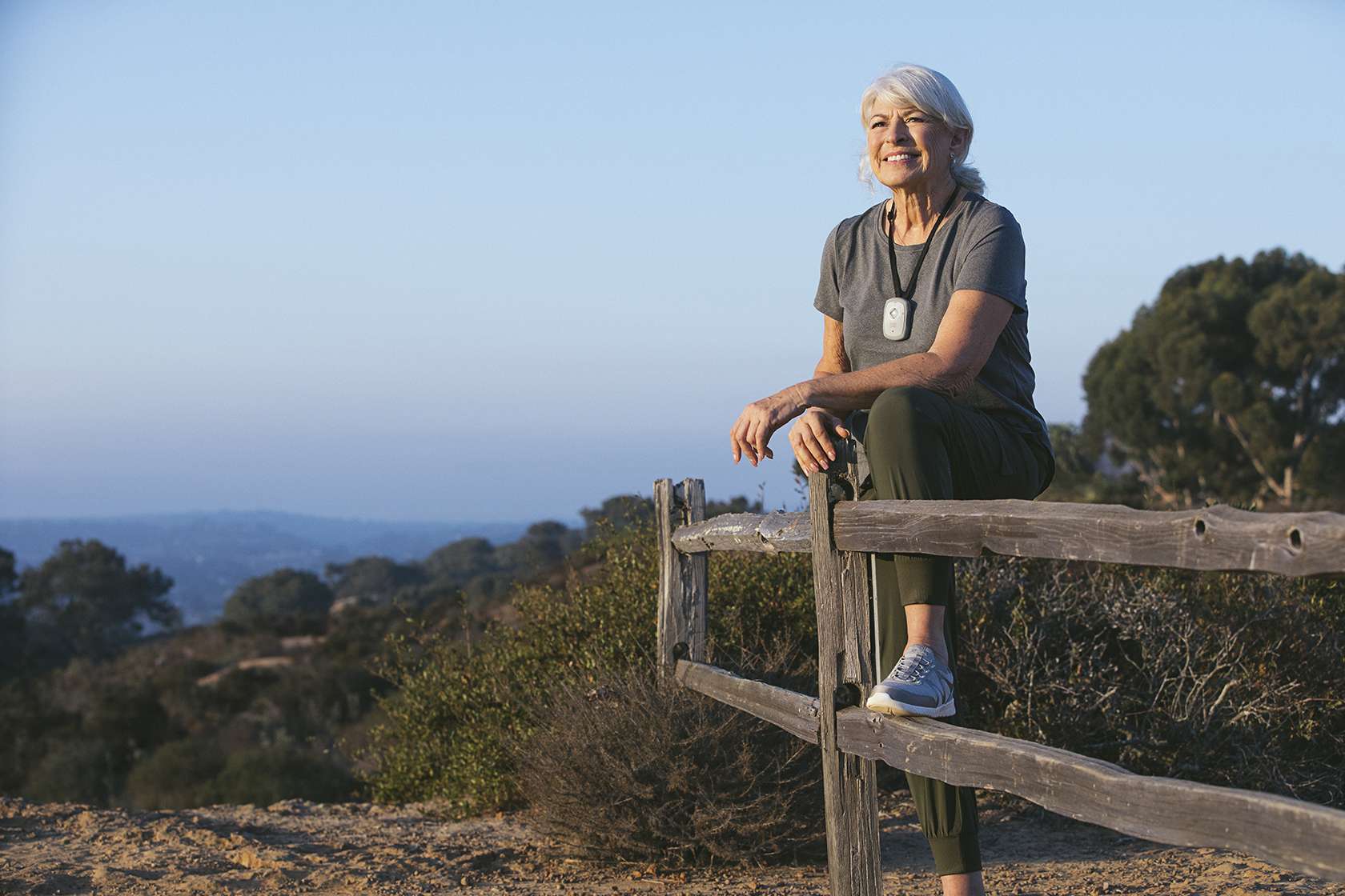 Senior wearing a Numera Libris 2 device while hiking staying safe and connected with real-time location tracking and emergency alerts.